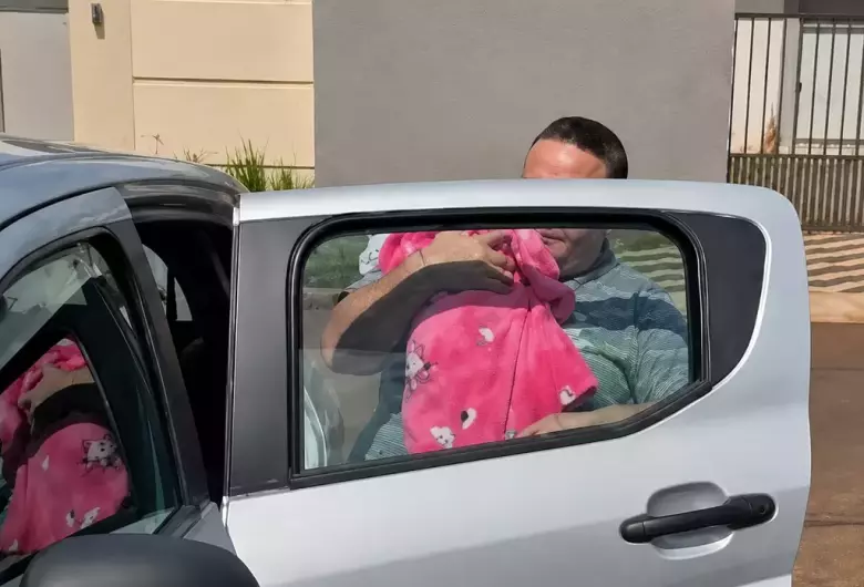 Bebê no colo de conselheira tutelar após entrega em Ponta Porã - Crédito: (Reprodução)